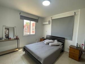 a bedroom with a bed and a large screen at Sunflower Oroklini in Voroklini +4 photos