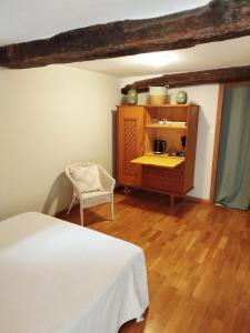 a bedroom with a bed and a cabinet and a chair at Mas des Carlines in Les Plans