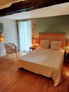 a bedroom with a large bed and a chair at Mas des Carlines in Les Plans