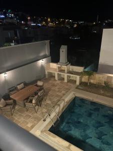 Un patio con una mesa y una piscina. en Villa Maye Eskiçeşme - Gümbet, en Bodrum City