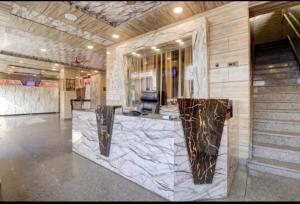 a lobby with a marble counter in a building at Ghanshyam Lodge Unit 1 in Ghaziabad +2 photos