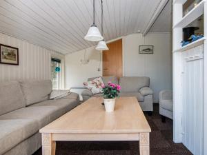 a living room with a couch and a table with flowers on it at 6 person holiday home in Glesborg in Glesborg