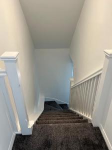 a stairway with white walls and white stairs at Gatwick 2 Bed Apartment 4 in Horley