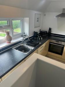 a kitchen with a sink and a stove at Gatwick 2 Bed Apartment 4 in Horley +13 photos