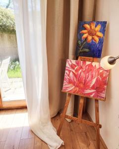 een schilderij op een ezel naast een schilderij van een bloem bij Garden-Apartment next to the forest, free parking in Schonach