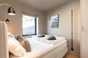 a room with a bed with pillows and a window at Åre Travel - Holiday Village in Åre