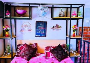 una camera da letto con un letto rosa e scaffali con fiori di Spatii Apartment a Rishikesh