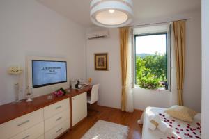 a bedroom with a dresser with a television and a window at Luxury Rooms Duje in Split