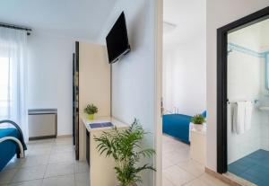 a bathroom with a shower and a television in a room at Sympathy Hotel in Martinsicuro