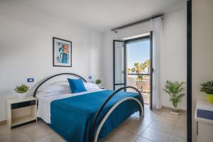 a bedroom with a bed with blue sheets and a window at Sympathy Hotel in Martinsicuro +31 photos
