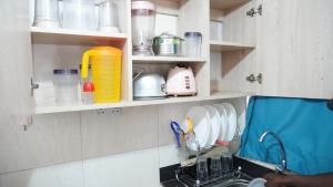 a kitchen with a sink and some dishes on shelves at Affordable Comfort Stay Lumumba Drive,Nairobi in Nairobi