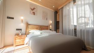 a bedroom with a large bed and a window at Nostalgia 28 lodge in Baisha