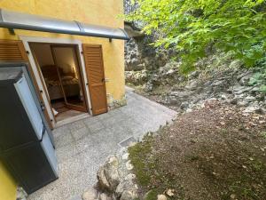 a building with a sliding glass door next to a sidewalk at Massone Climbing House - Holiday Home Garda Trentino in Arco