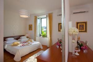 una camera con letto, tavolo e finestra di Luxury Rooms Duje a Spalato (Split)