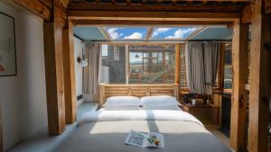 twee bedden in een kamer met een raam bij Nostalgia 28 lodge in Baisha +86 foto's