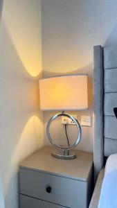 a lamp on a night stand next to a bed at Urban Studio Gem in South B Work Desk Near Airport in Nairobi