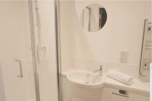 un bagno bianco con lavandino e doccia di Redcross street studios 308 a Bristol