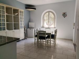 a kitchen with a table and chairs and a window at Villa Ausilia in Saline Joniche