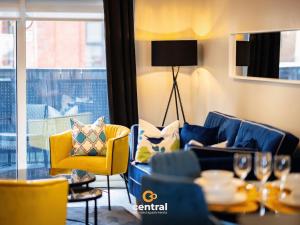 a living room with a blue couch and yellow chairs at Trades Lane by CENTRAL SERVICED APARTMENTS - City Centre - 2 Bedrooms - En-Suite Bathroom - Dedicated Parking Space - Fully Equipped - Walk Away From Dundee Bus & Train Station - City Centre - Fully Equipped in Dundee