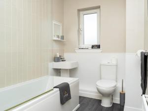 a white bathroom with a toilet and a bath tub at Trades Lane by CENTRAL SERVICED APARTMENTS - City Centre - 2 Bedrooms - En-Suite Bathroom - Dedicated Parking Space - Fully Equipped - Walk Away From Dundee Bus & Train Station - City Centre - Fully Equipped in Dundee +46 photos