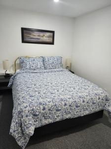 a bedroom with a bed with a blue and white comforter at 12 Royal Masts Way in Halifax