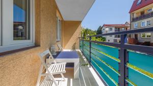a balcony with two chairs and a swimming pool at Leśna II, Sun & Snow in Hel