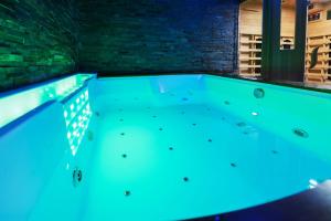 einen Whirlpool in einem Zimmer mit blauer Beleuchtung in der Unterkunft Appartement Spa et Sauna privatif - Terrasse in Carcassone