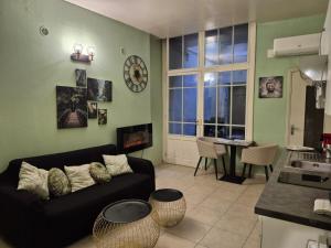 ein Wohnzimmer mit einer schwarzen Couch und einem Tisch in der Unterkunft Appartement Spa et Sauna privatif - Terrasse in Carcassone