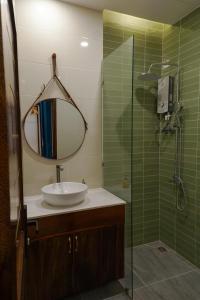 ein Badezimmer mit Waschbecken und Dusche mit Spiegel in der Unterkunft CLOVER Homestay Phú Yên in Phường Sáu