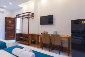 a bedroom with a bed and a desk with chairs at CLOVER Homestay Phú Yên in Phường Sáu