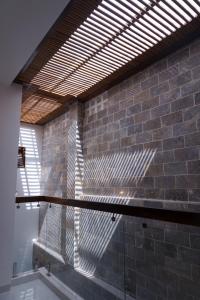 ein Gebäude mit Ziegelwand und Holzdach in der Unterkunft CLOVER Homestay Phú Yên in Phường Sáu