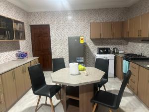 a kitchen with a table and chairs and a refrigerator at Biztourism Gh in Accra