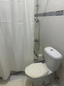 a white bathroom with a toilet and a shower at Biztourism Gh in Accra