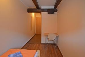 a room with a bed and a table and a chair at Pension Am Pilgerbach in Baunatal