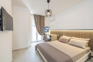 a bedroom with a bed and a tv in it at Villa Irene Deluxe in Campofelice di Roccella