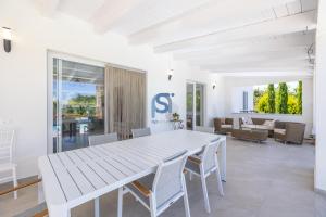 a white dining room with a white table and chairs at Villa Irene Deluxe in Campofelice di Roccella