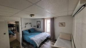 una piccola camera da letto con un letto blu e una finestra di Appartement 200m carré mont dore a Le Mont-Dore
