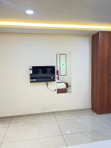 a room with a tv on a white wall at Hotel X Fortune in Jāmb