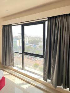 a large window with black curtains in a room at Hotel X Fortune in Jāmb