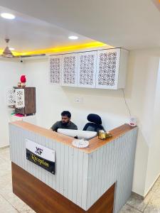 a man sitting at a reception counter in a room at Hotel X Fortune in Jāmb