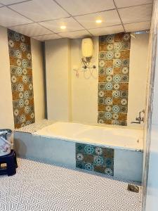 a bathroom with a tub and a tile floor at Hotel X Fortune in Jāmb +19 photos