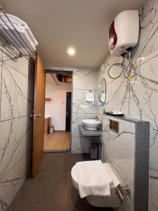 a bathroom with a sink and a toilet and a mirror at Hotel Royal Galleria in Vadodara