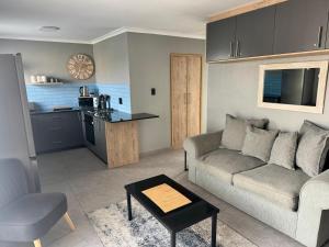 a living room with a couch and a kitchen at Serenity in Langebaan