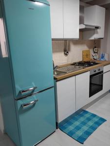 a blue refrigerator in a kitchen with white cabinets at A casa di Mary in Vieste
