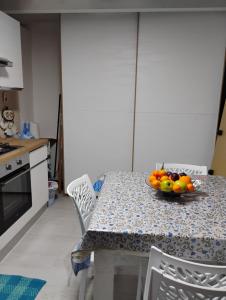 a kitchen with a table with a bowl of fruit on it at A casa di Mary in Vieste