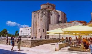 a group of people standing in front of a building with umbrellas at Mary in Zadar