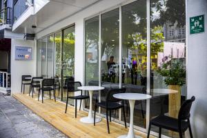 a row of tables and chairs in front of a building at Terminal 27 Hotel in Hulhumale