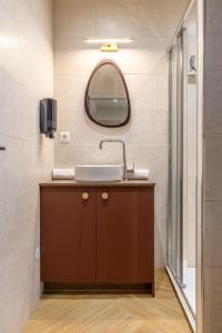 a bathroom with a sink and a mirror at Studio Chic & Spacieux Hyper-Centre Clermont C in Clermont-Ferrand