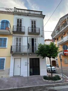 a white building with balconies and a car parked in front at Cairoli House- Grottammare in Grottammare