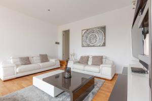 ライプツィヒにある10-12 Personen - Luxus Penthouse Leipzig Zentrum - Thomaskircheのリビングルーム(白いソファ2台、テーブル付)